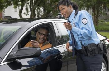 female police officer giving directions to older driver 