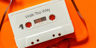 Image of a white cassette tape with Walk This Way written on the front. 