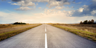 Image of an open, rural road with a blue sky background