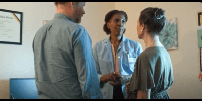 An older adult and her son speaks with a clinician 