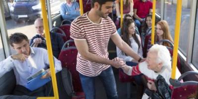 Man helping older woman on a bus